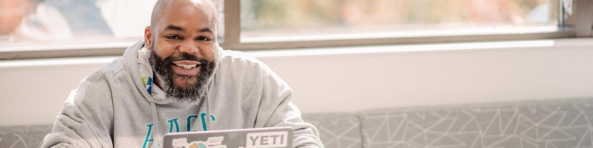 Student smiling for camera while sitting at table
