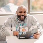 Student smiling for camera while sitting at table