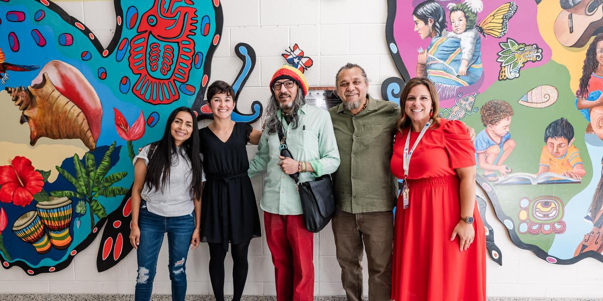 The Tyler Heights Principal, Wilfredo and student artists pose together in front of the mural.
