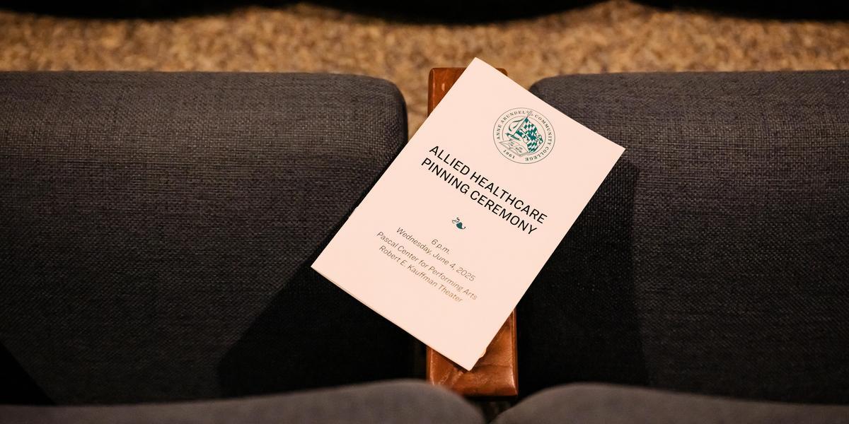 Program for the Allied Healthcare Pinning Ceremony resting on a seat in the theater.
