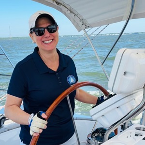 Claudine steering a boat.