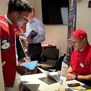 Student at display table with a representative from a college.