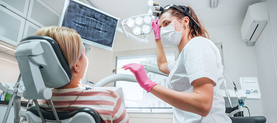 A dental hygienist shows a patient an x-ray of their teeth