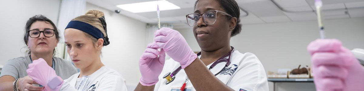 Nursing students learning how to use syringes