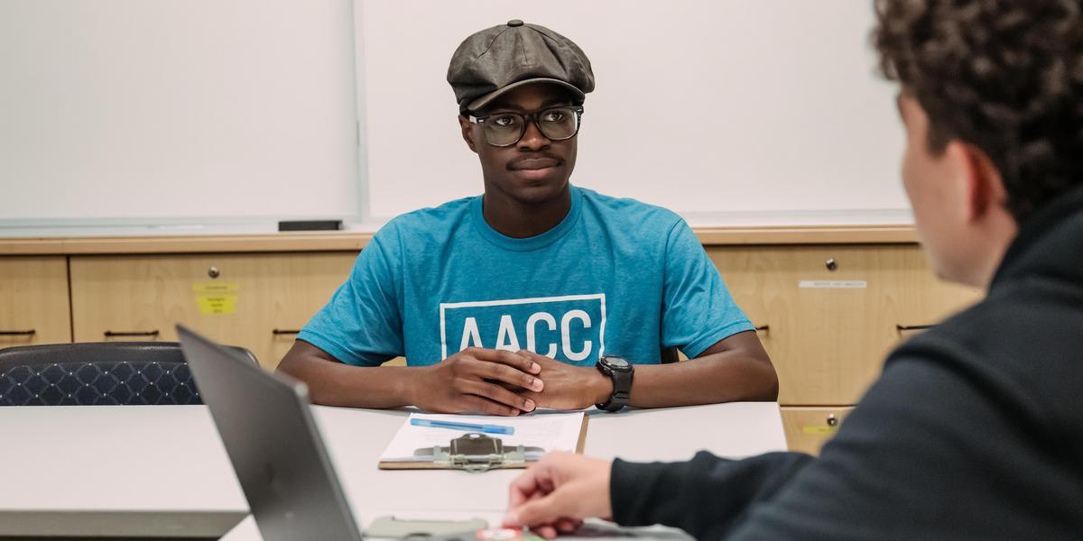 Student inside the legal clinic talking to another student.