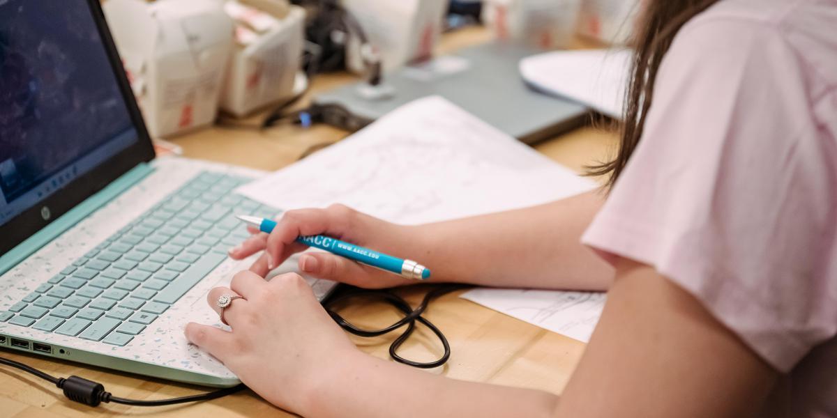 Student's hands typing on a laptop