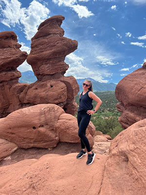 Lonni Summers stands on a red rock formation