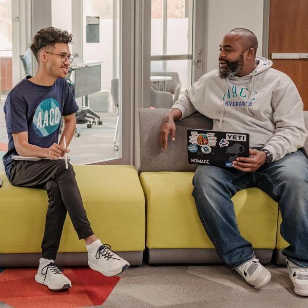 Two students sitting outside IDEA Lab.