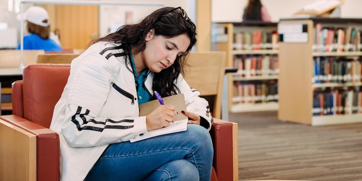 Student writing in a notebook.