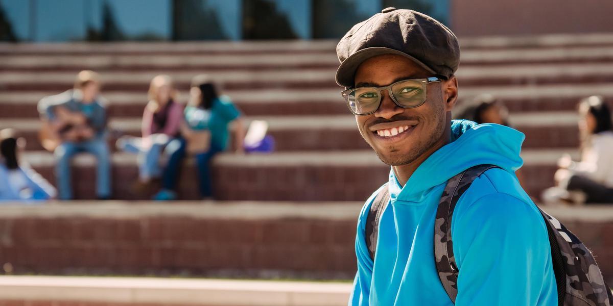 Student posing with other students in the background.